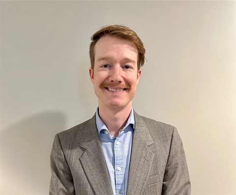 A youngish man with reddish hair and a mustache 